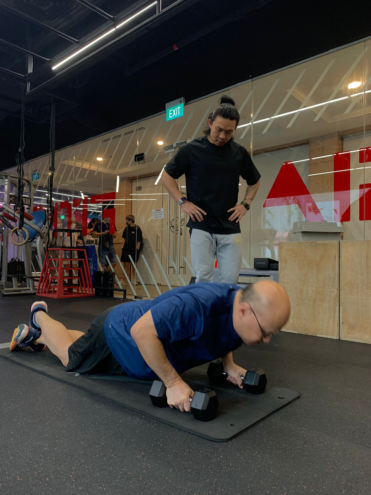 Edison Ho supervising an adult client during strength training